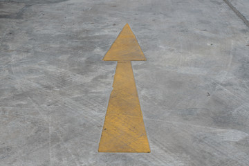 Yellow arrow on cement floor