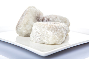 Fototapeta na wymiar Japanese confection, round glutinous rice stuffed with sweetened red bean paste or locally known as daifukumochi in a white plate over white background