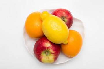 two orange and apple fruits with one lemon