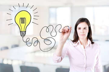 Businesswoman drawing bulb light. Office background.