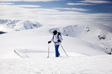 Fototapeta na wymiar Cross-country skier - snowy mountains in the background
