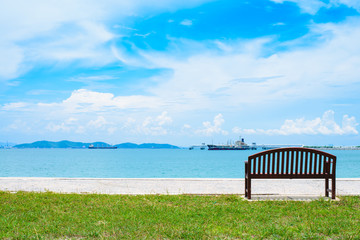 An empty wooden bench with a viewpoint looking out to sea.