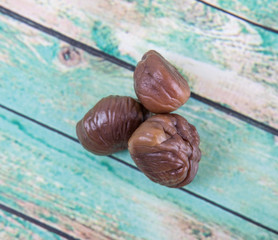 Roasted whole peeled chestnut over wooden background