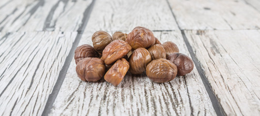 Roasted whole peeled chestnut over wooden background