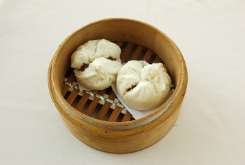 Barbecued pork buns. yumcha. dim sum in bamboo steamer with chinese bun, pao, bao zi, steamed dumpling, shumai on table in chinese restaurant. chinese cuisine.

