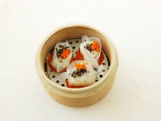 Steamed scallop dumpling. yumcha. dim sum in bamboo steamer with chinese bun, pao, bao zi, steamed dumpling, shumai on table in chinese restaurant. chinese cuisine.
