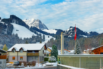 Buildings of the town of Gruyeres standng out against snow-cover