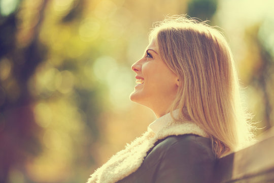 Young happy woman enjoying fresh air in autumn, intentionally toned.