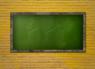 Blackboard on a yellow brickwall