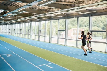 Couple running on the indoor track