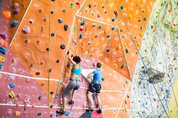 Fit couple rock climbing indoors  - Powered by Adobe