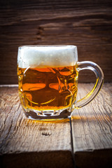 Pint of beer on a wooden table.