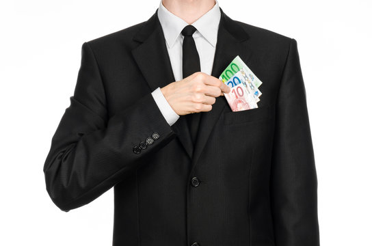 Money and business theme: a man in a black suit is holding euro money isolated on white background in studio