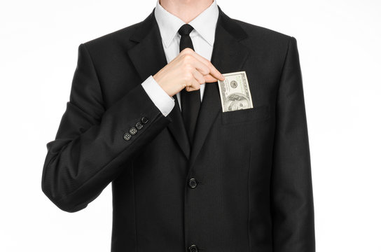 Money and business theme: a man in a black suit holding a bill of 100 dollars and features a hand gesture on an isolated white background in studio