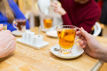 close up of female hand with tea  cup at cafe