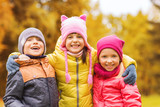 group of happy children hugging in autumn park