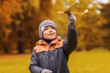 happy little boy playing with toy plane outdoors