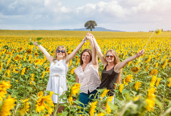 Three young friends in a sunflower field