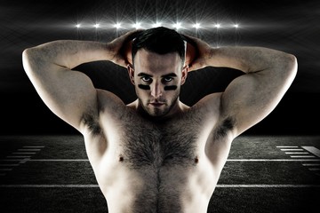 Composite image of shirtless american football player with ball