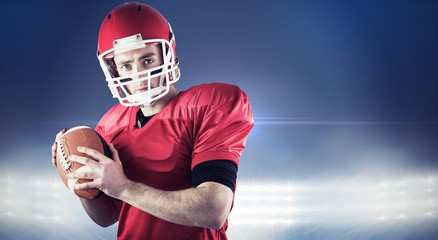 Composite image of american football player holding ball