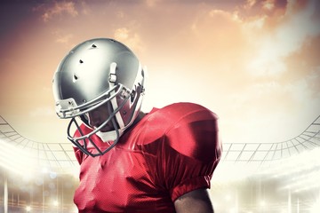 Composite image of american football player looking down