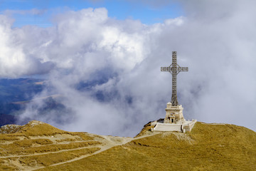 Caraiman cross (heroes monument) from the Bucegi mountains, Romania, in a scene with low clouds that surround it