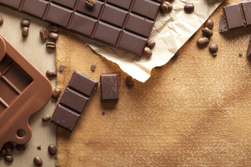 Dark chocolate and coffee beans on old paper background
