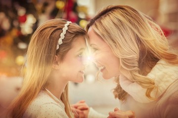 Festive mother and daughter beside christmas tree