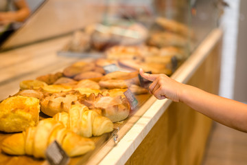 Child's hand with index finger pointing on some fresh pastry