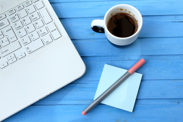 Lap top, black coffee, sticky note and pink pen