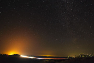 Highway on a background of bright stars of the night sky and the