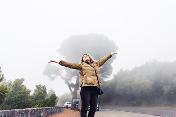Fototapeta na wymiar Woman walking in foggy forest 