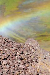 Rainbow over the rocks near the dam