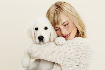 Beautiful woman hugging puppy, close up