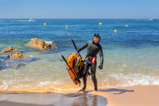 Underwater hunter in flippers preparing to dive. Underwater fishing in the Atlantic Ocean.