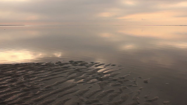 Gentle waves over the Wadden Sea in The Netherlands in the morning light.