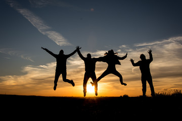 People Silhouette / Family jumping together in the sunset    