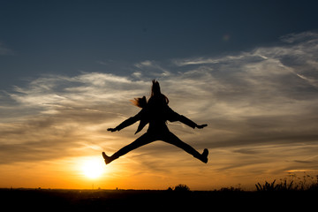 Fototapeta na wymiar People Silhouette / Girl jumps in the sunset 