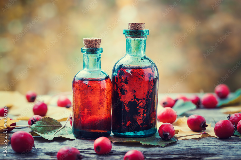 Poster tincture bottles of hawthorn berries and red thorn apples on woo