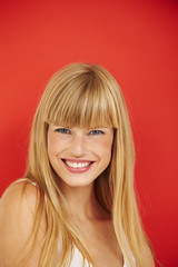 Fototapeta premium Happy young woman against red background