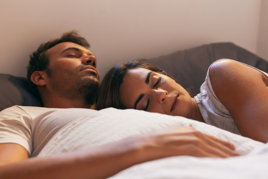 Young Couple Sleeping in Bed with Morning Light