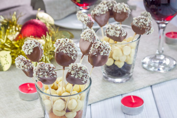 Homemade apricot and prunes lollipops, covered with chocolate and macadamia nuts