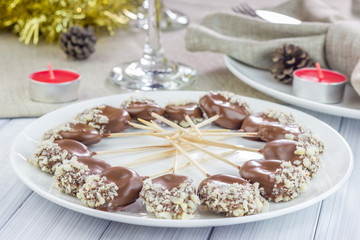 Homemade apricot and prunes lollipops, covered with chocolate and macadamia nuts