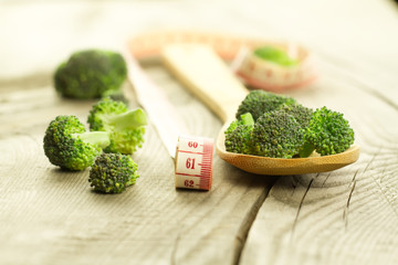 fresh broccoli in a spoon on wooden background. healthy food, vegetarian, slimming, diet.