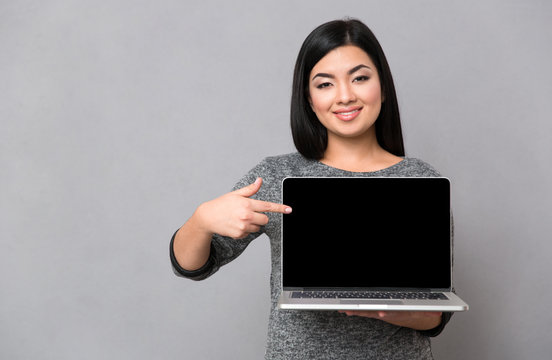 Woman pointing finger on blank laptop computer screen