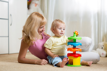 mother and her child playing with colorful logical toy