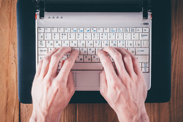 Man hands writing text on laptop