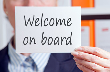 Welcome on board - Woman with sign and text in the office