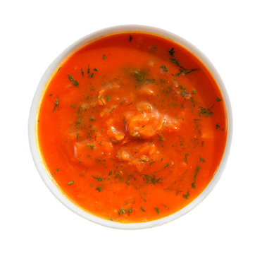 Spicy pumpkin soup in a white plate. Isolated photo.