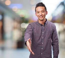 portrait of young asian man doing a welcome gesture